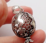 A sterling silver 925 pendant necklace with a pomegranate design, featuring faceted garnet stones.