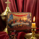 Close-up of the Holy Supper Byzantine style Christian icon in bright colors of red and golden tints on a wooden display stand with a candle and golden cross.