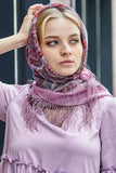 A woman with head shawl in purple colors with fringe