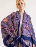 A woman wearing a purple shawl with light blue and red pattern in Slavic traditional style. Made of natural merino wool, large size, with silky fringe, easy to wrap.