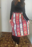 A person wearing a traditional Armenian taraz apron with a geometric pattern in red and blue colors.