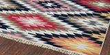 Multicolored patterned rug kilim on a wooden floor for Provence country style house decor