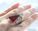 A sterling silver 925 set including very long earrings and a ring, featuring burnt orange faux stone.