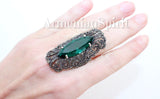 A large long finger covering ring of sterling silver jewelry featuring green topaz stones and marcasite on a hand, with Armenian Spirit title.
