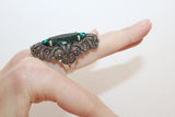 Extra long ring with marcasite and transparent green stone on a middle finger.