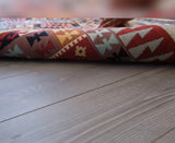 Person rolling out a patterned rug on a wooden floor
