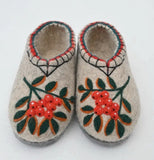 Pair of felted slippers with floral and rowanberry design on a white background