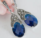 Royal blue faceted gemstones earrings with marcasite on a white background.