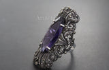 Long ring with marcasite and purple bright transparent gemstone on a black surface with brand name Armenian Spirit.