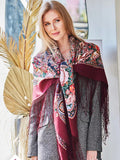 This extra-large square wrapping scarf showcases a deep wine red base with vintage-inspired peony flowers in pink and beige. Woven from premium merino wool, it offers both comfort and sophisticated beauty.