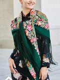 A woman wearing this sea-green merino wool shawl on her shoulders stands out with its pink peony flowers and simple turquoise accents. The oversized size and long silky fringe makes it perfect for cold days and stylish layering.
