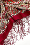 Red paisley scarf with intricate patterns on a white background