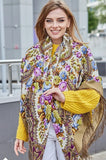 Woman wearing a yellow Slavic scarf with vintage field flowers and silky fringe. The material is high quality natural merino wool.