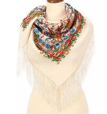 Colorful patterned Slavic ivory scarf with green and red herbal pattern and  fringes on a mannequin against a white background