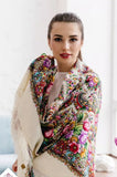 A beautiful Slavic girl with large white off shawl with bright flowers in traditional slavic style with fringed edges.