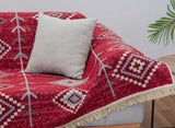 Red patterned rug in Armenian traditional daraz style with white pillow on a sofa. Buy for cafe in Armenian traditional style for covering the floor or the sofas.