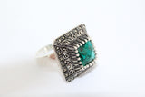 Buy emerald green zircon ring, with the ring featuring a square design and marcasite shiny stones on a white background.