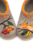 Pair of children's and women`s woolen slip on chuni slippers with a squirrel and berry design on a white background