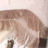 A close-up of a light beige fringed Slavic table cloth with fringe