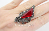 This ring is not for the faint of heart; it's a bold declaration of vintage style and a captivating nod to medieval aesthetics. The large red stone, the centerpiece of this piece, is undeniably eye-catching. Its rich color immediately draws the gaze, lending a sense of drama and perhaps even a touch of mystique. The stone reminds a royal ruby.
