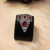 An adjustable sterling silver thumb ring with a triangular shape featuring lab light blue turquoise stones on a black background.