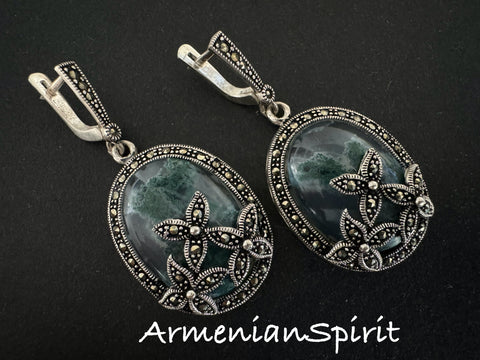 Expertly crafted from high-quality sterling silver 925, these handmade Armenian earrings feature striking moss agate stones in a rich green hue. The intricate flower design, accented with small marcasite stones, adds a touch of elegance to these very big earrings. With a secure English lock, these earrings are both stylish and functional.
