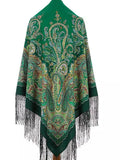 This green Slavic shawl with yellow patterns feels warm and elegant. A woman wearing it enjoys the depth of color and simple beauty. The shawl adorned with long silky fringe.