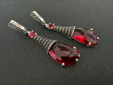 Handcrafted in Armenia, this vintage-inspired sterling silver jewelry set exudes luxurious elegance. Adorned with ruby red gemstones and sparkling marcasites, the large ring and long dangle earrings are perfect to elevate any outfit. Treat yourself or a sophisticated loved one to this exquisite gift.

