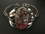 Vintage Silver bracelet with a large oval leopard pattern gemstone on a dark background
