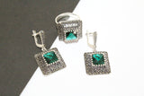 A set consisting of emerald green zircon earrings and a ring, with the ring featuring a square design on a white background.