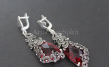A set of red crystal triangular earrings and ring, with intricate silver designs and embellishments.