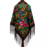 Colorful embroidered shawl with floral patterns and black fringe on a white background