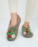 Pair of medical warm woolen slippers with floral and berry designs on a white background