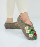 Felted warm slippers with floral and berry design worn by a person on a white background
