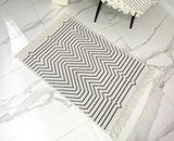 Black and white zigzag patterned rug on a marble floor