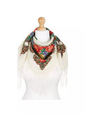 Decorative scarf with floral patterns and fringes on a mannequin against a white background