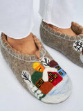 Woolen chuni for men and women with fairy tail houses and trees in snow on a woman`s feet.