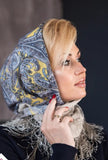 Woman wearing a patterned headscarf made of warm merino wool with yellow and gray accents.