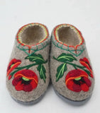 Pair of 100% sheep wool slippers with poppy floral embroidery on a white background