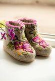Floral embroidered women woolen booties with purple orchid flower on a light background