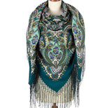 Teal patterned woolen scarf with silky fringe on a mannequin against a white background