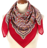 Red woolen scarf with intricate herbal pattern on a mannequin