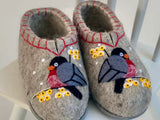 Pair of handwoven woolen  slippers with bird and flower design on a white surface