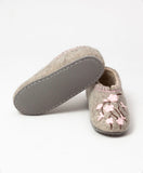 House shoes made of natural merino wool with rubber outsole and pink flowers on white background.
