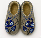 Woolen indoor slippers with Slavic blue and white traditional flower on a white background.