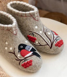 Pair of gray woolen bootie slippers with bird and berry design on a white surface