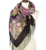 Colorful Slavic floral and paisley patterned scarf with black fringe on a mannequin against a white background