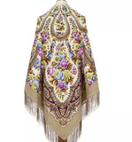 Oversized wrapping shawl with floral patterns and fringes on a yellow background made of merino wool.