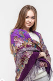 Woman wearing a purple peony floral patterned scarf made of merino wool and silky fringe.