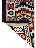 Armenian ethnic reversible rug with traditional geometric ornaments in navy blue and red on a living room floor. Cozy farmstyle living room decor featuring a navy blue and red Armenian traditional patterned carpet.